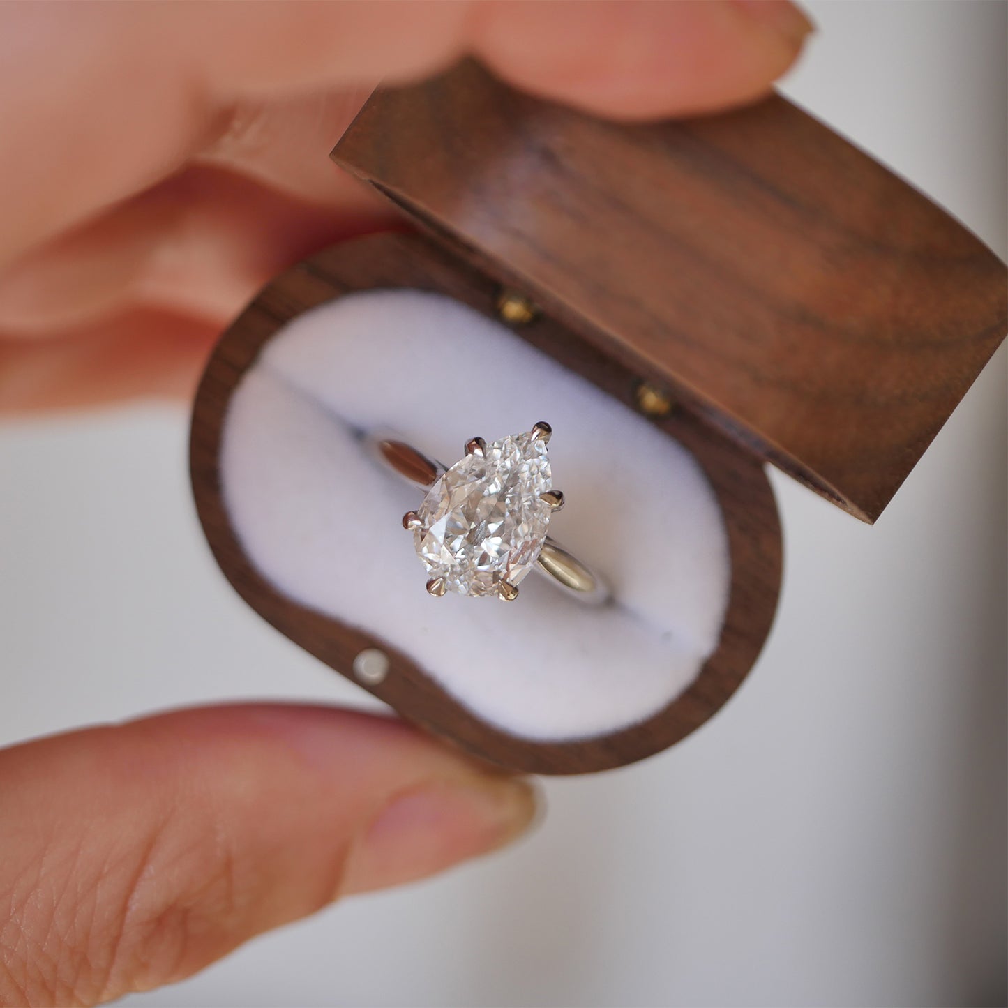 One of a kind vintage wood ring box with lab grown pear shaped diamond ring.