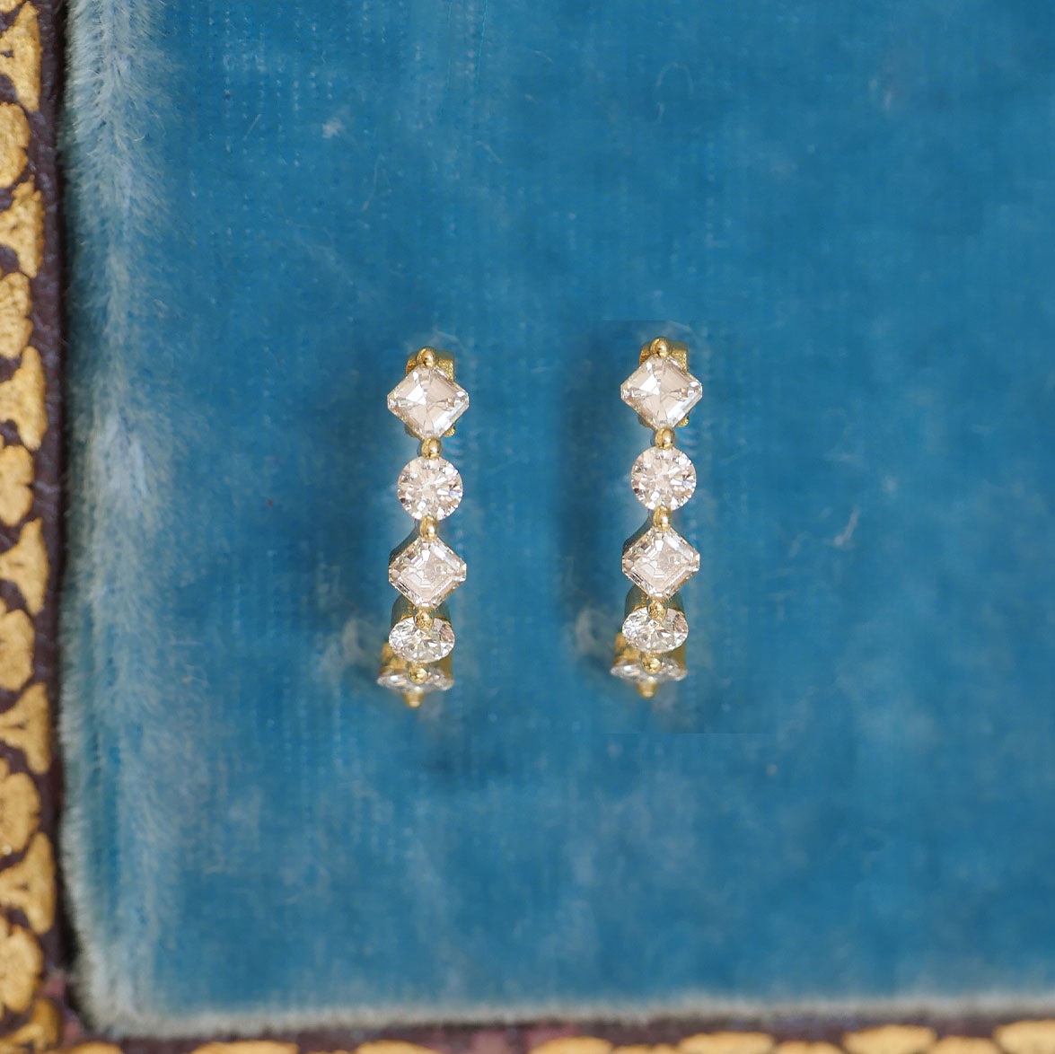 Pair of vintage diamond hoop earrings with six asscher cut diamonds and four round diamonds set in 18k yellow gold.