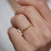 Woman wearing a criss cross engraved yellow gold wedding band.