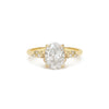 An oval-shaped diamond ring with smaller round diamonds set in a 14k yellow gold band