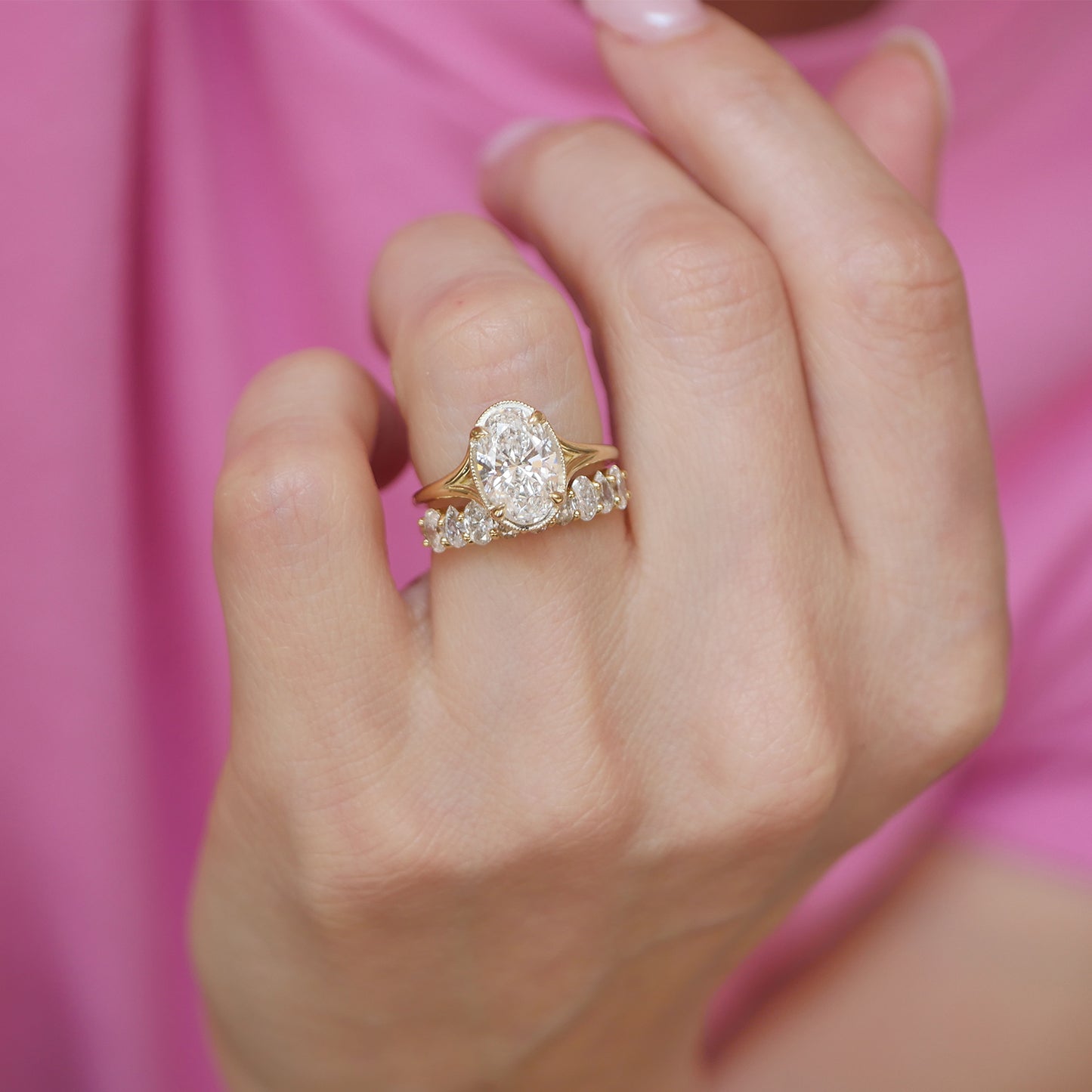This exquisite engagement ring showcases oval brilliant cut diamonds in a split shank setting, paired with diamond wedding bands that add a touch of refinement and sparkle to the ensemble.