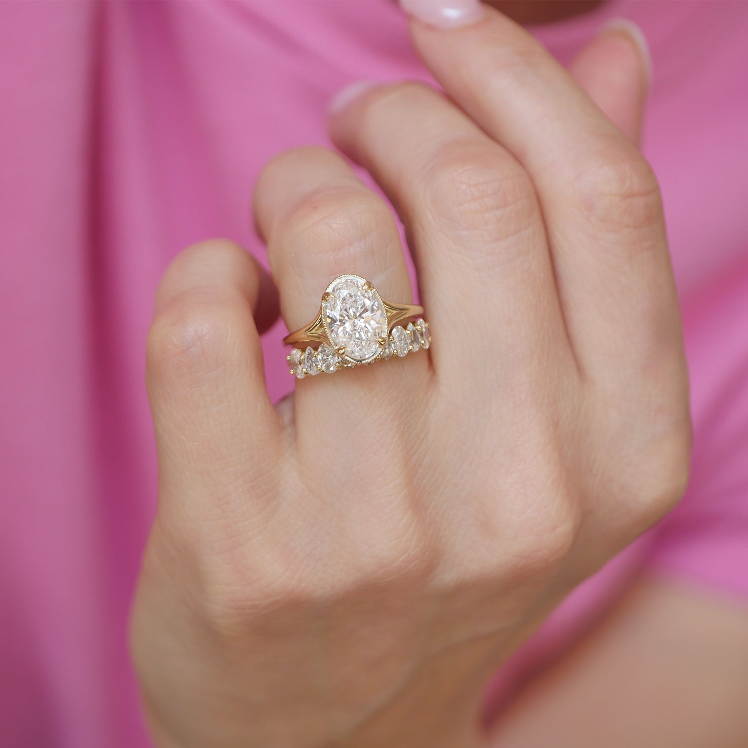 This exquisite engagement ring showcases oval brilliant cut diamonds in a split shank setting, paired with diamond wedding bands that add a touch of refinement and sparkle to the ensemble.