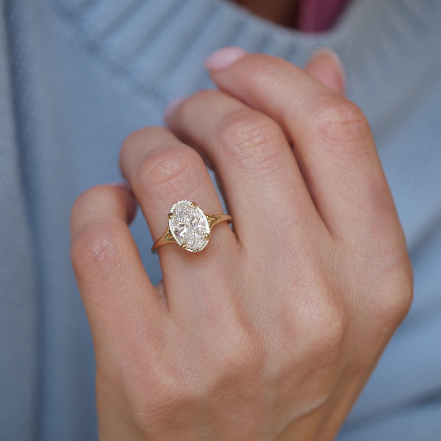A gorgeous split shank setting holds oval brilliant cut diamonds, and when paired with complementary contour diamond wedding bands, it creates a harmonious and dazzling look for the perfect wedding set.