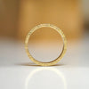 Profile view of a man's wedding band with floral engraving set in 14k yellow gold.