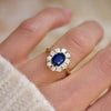 Woman wearing a blue sapphire and old european diamond cluster rings.
