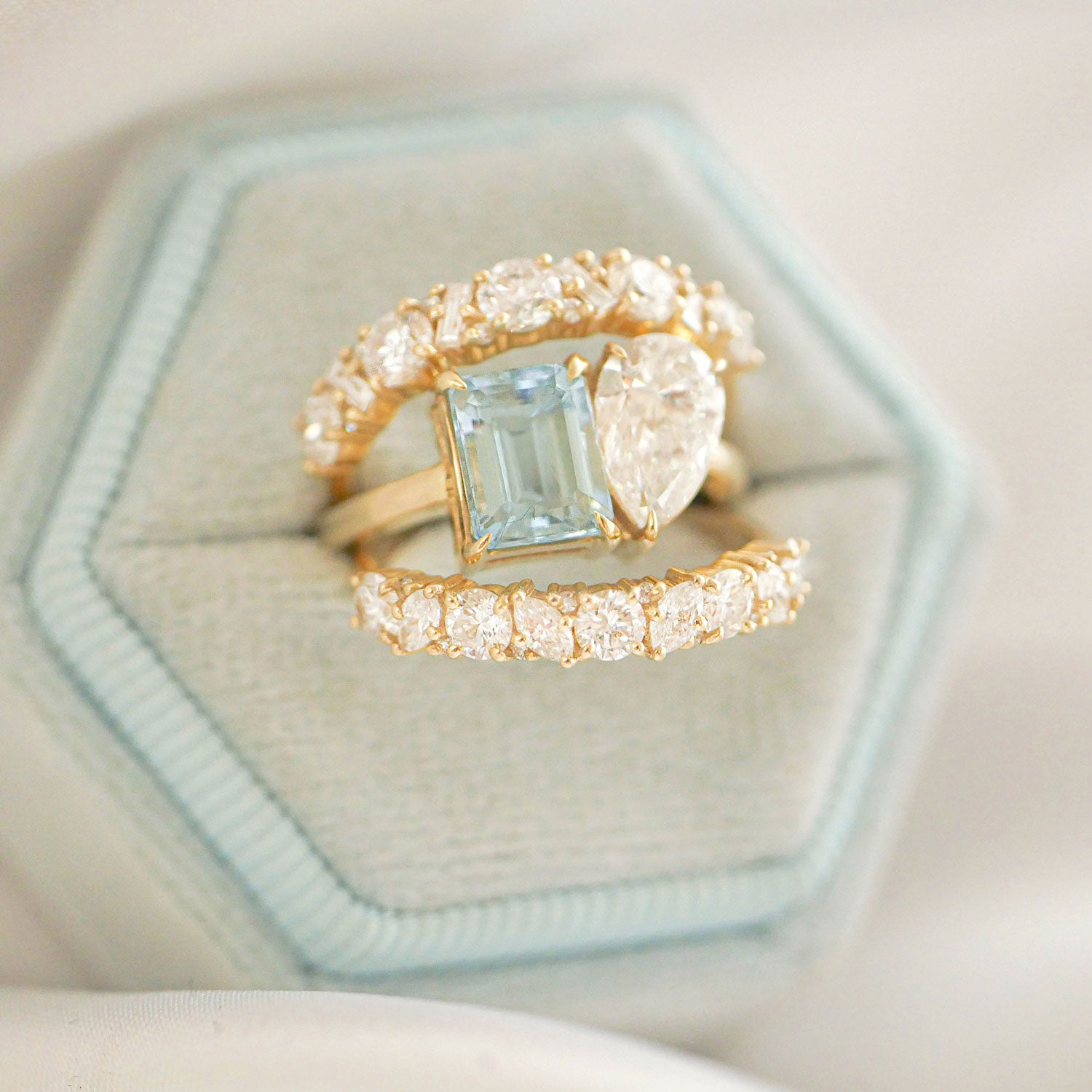 The Aquamarine & Pear Diamond Toi et Moi Ring offers a unique and romantic design, where the serene aquamarine and the radiant pear diamond come together to represent the union of two hearts. Stacked with two diamond confetti wedding bands.