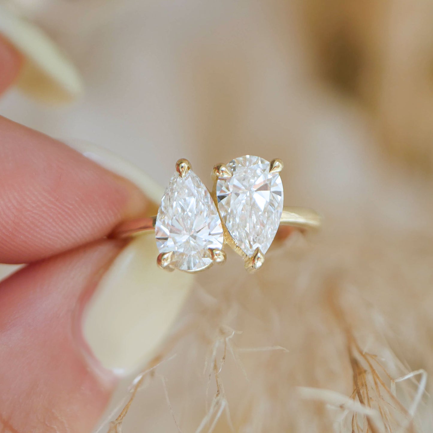 The graceful curves of the pear-shaped diamonds are set side by side, creating a stunning visual that symbolizes the perfect harmony and balance of a relationship.