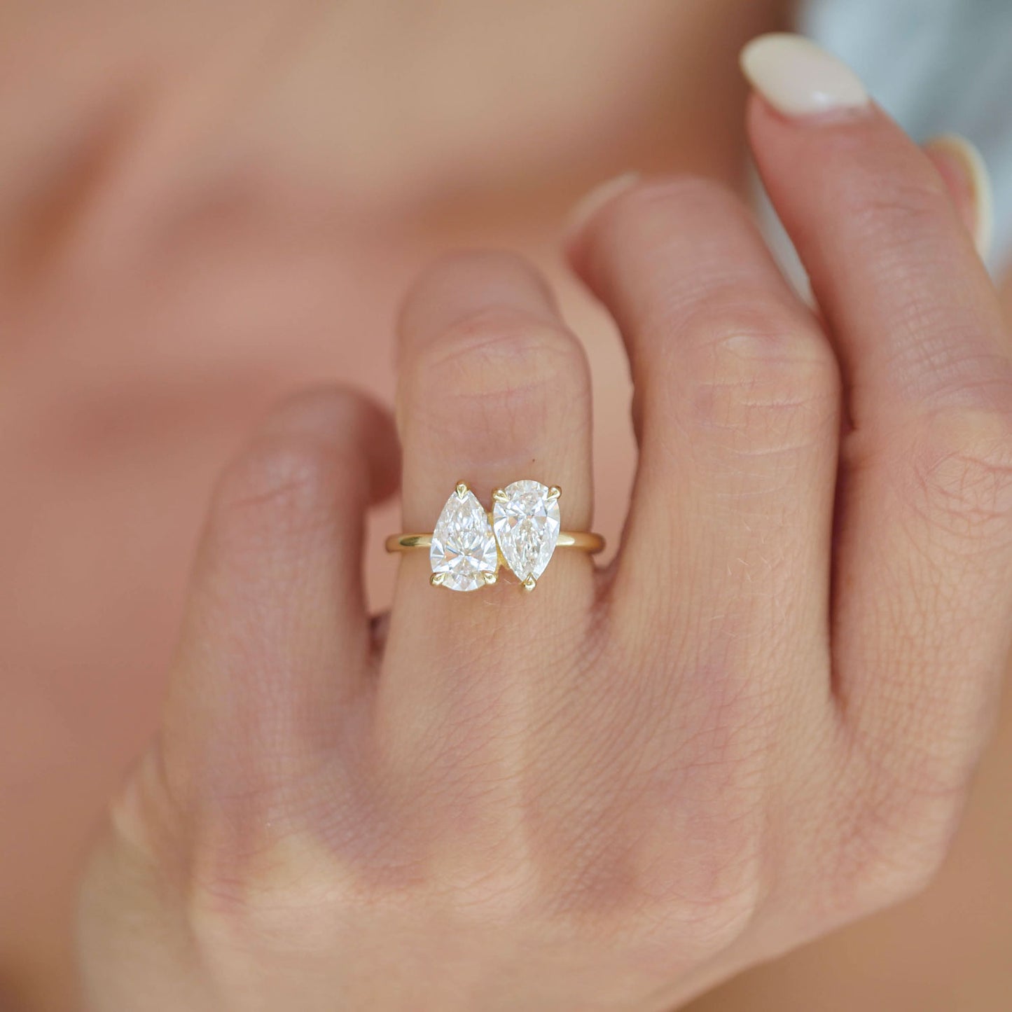 The two pear-shaped diamonds in this ring reflect light from every angle, creating a radiant and captivating display of brilliance and warmth.