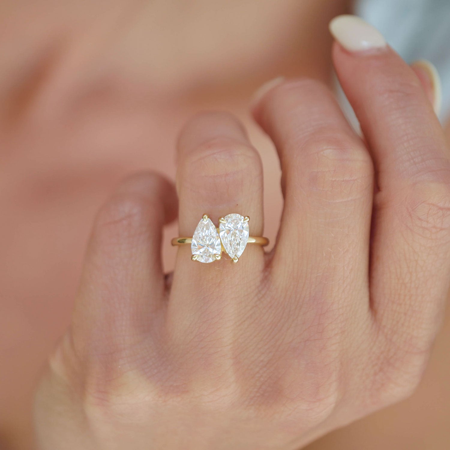 The two pear-shaped diamonds in this ring reflect light from every angle, creating a radiant and captivating display of brilliance and warmth.